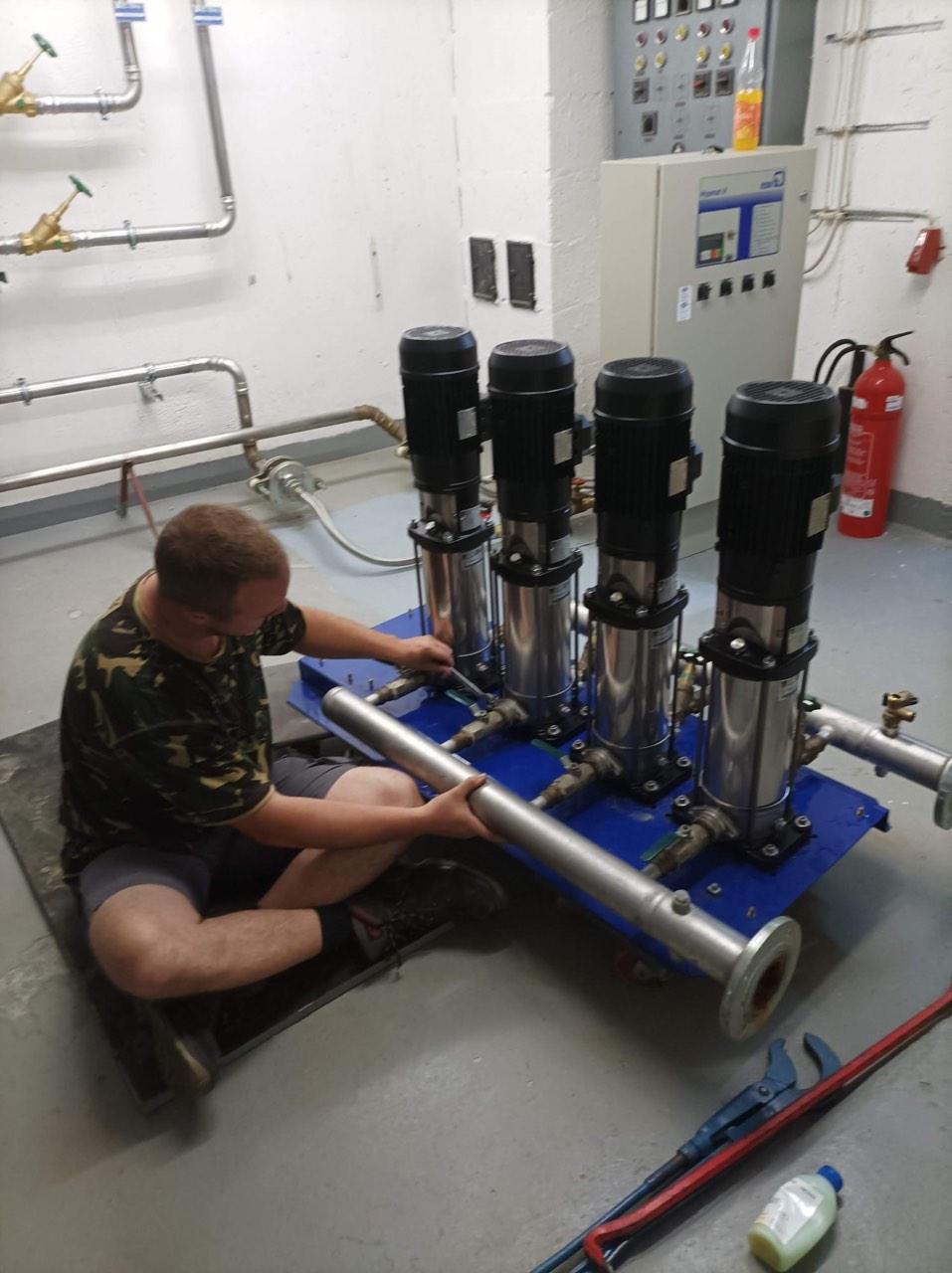 Techniker montiert die mehrstufigen Pumpen der Druckerhöhungsanlage